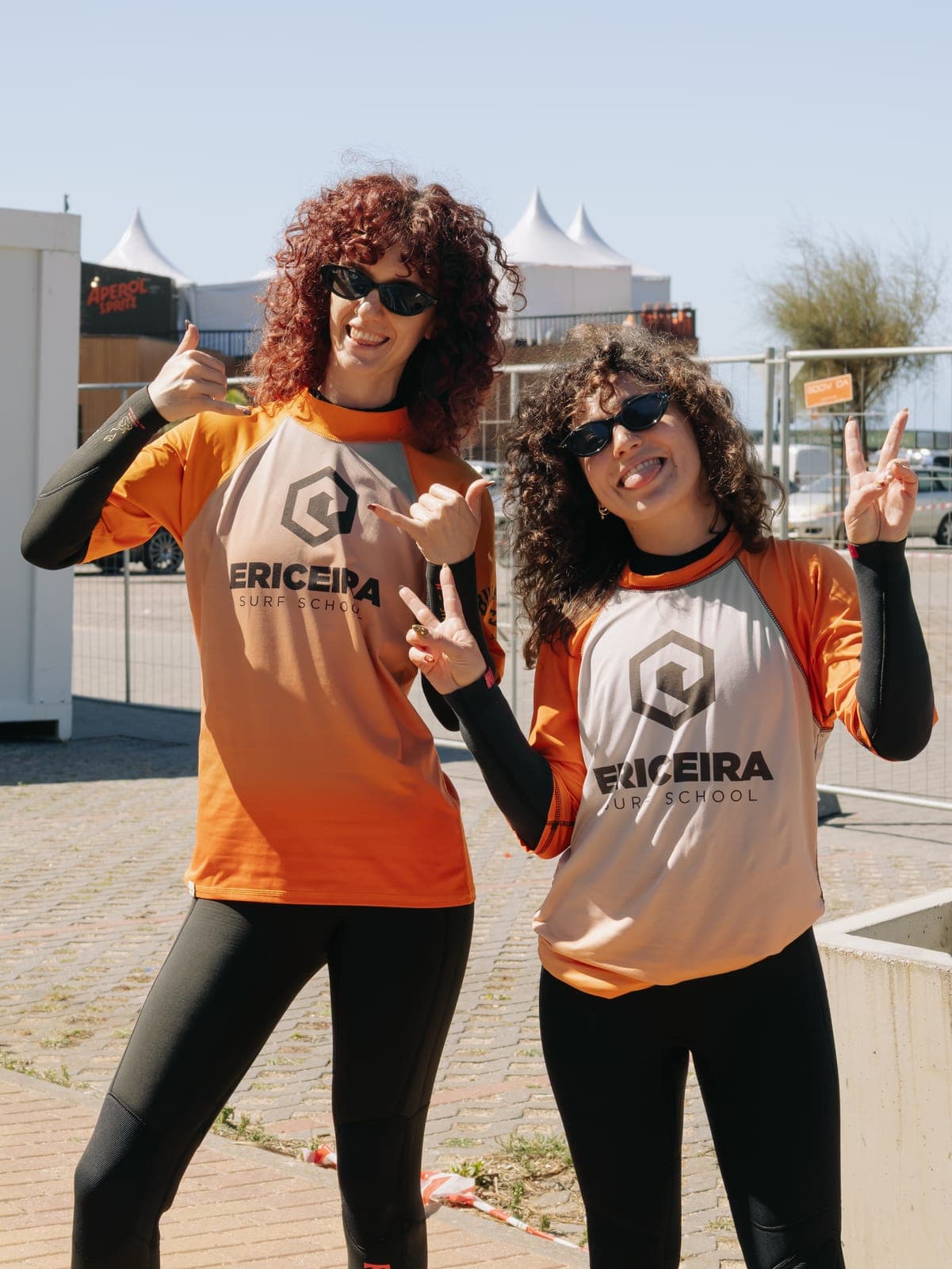Two team members in surf school rash guards before a surf lesson at the Portugal offsite
