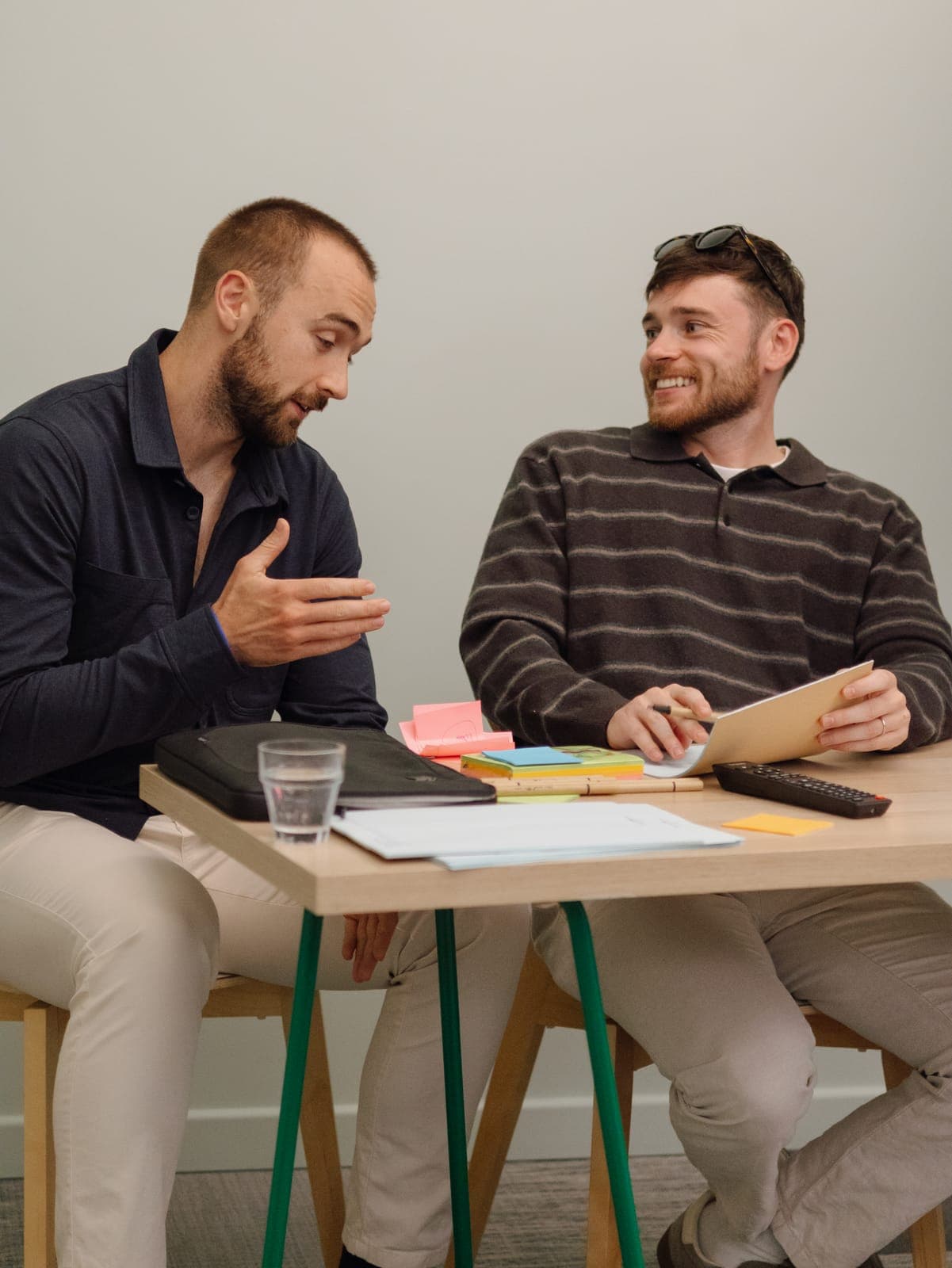 Two team members talking through an idea at a workshop table during the 2026 Portugal offsite